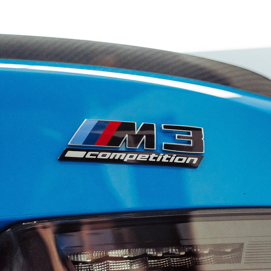 M3 Competition badge on a blue BMW M3
