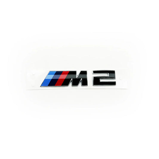 Genuine BMW Gloss black BMW M2 rear badge with silver outline and blue, red, and white colour stripes.