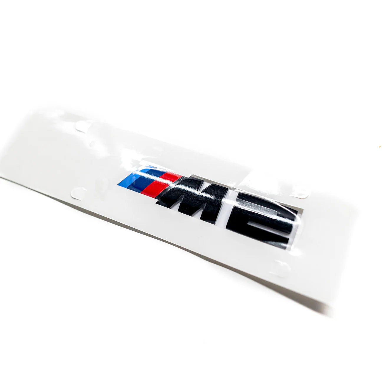 Gloss black BMW M2 replacement badge with red, white, and blue accents