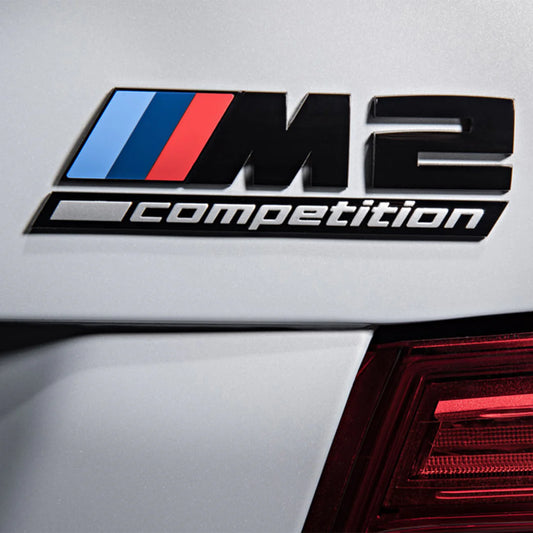 Genuine BMW, Gloss black BMW M2 Competition replacement badge on rear of white BMW M2. Close Up